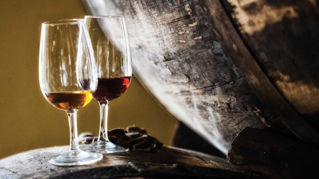 2 glasses of maderia wine on a wooden barrel